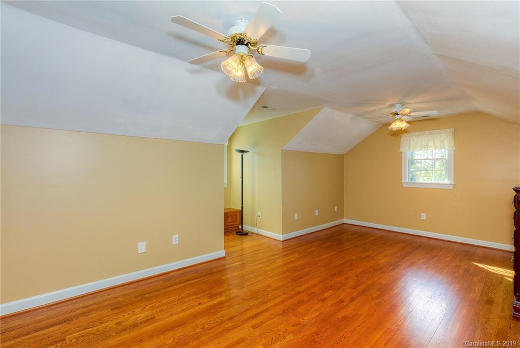 34863 Finger Road Mount Pleasant, NC 28124 - Photo 20 of 32 an empty room with wooden floor chandelier fan and windows