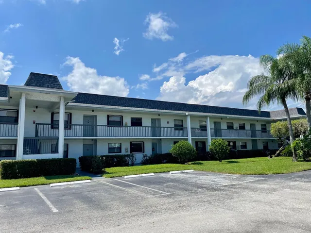 a front view of a house with a yard and potted plants