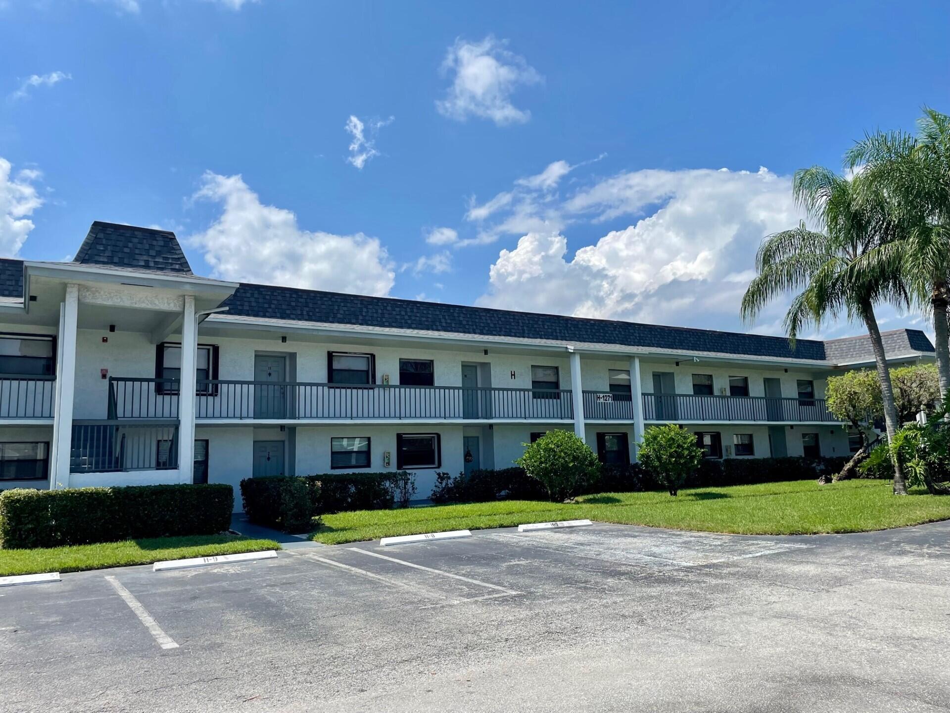 1271 Southeast Parkview Place, Unit H4 Stuart, FL 34994 - Photo 13 of 15 a front view of a house with a yard and potted plants
