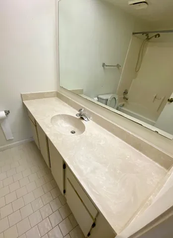 a bathroom with a granite countertop sink and a mirror
