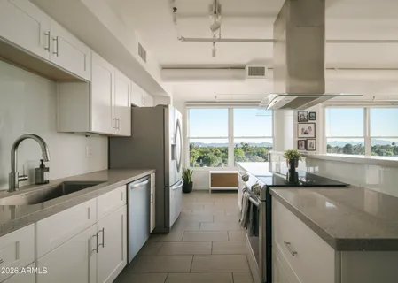 a kitchen with stainless steel appliances granite countertop a sink stove and cabinets