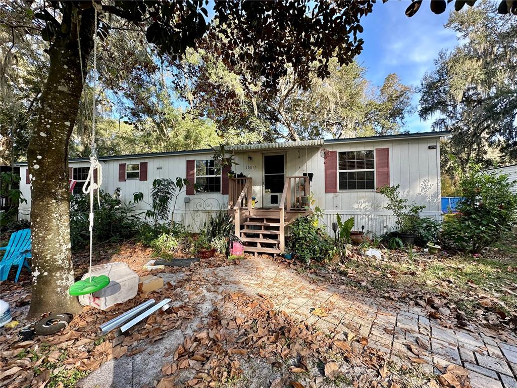 a view of a house with backyard and sitting area