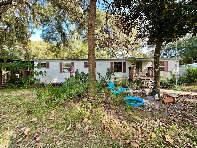 a view of a house with backyard sitting area and garden