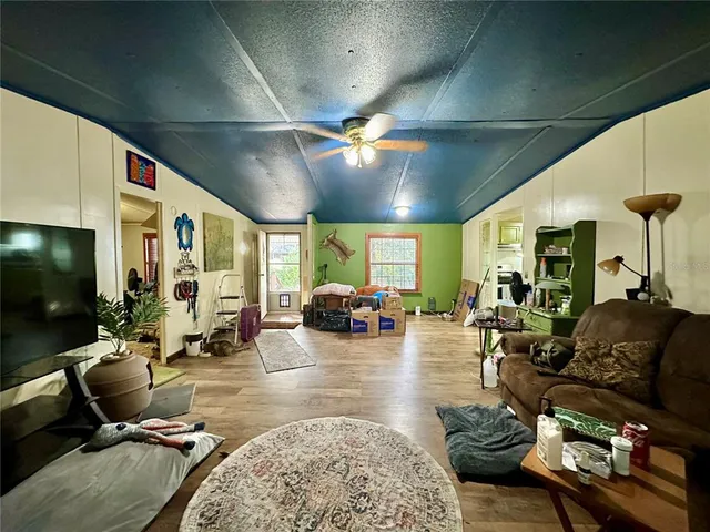 a living room with furniture a flat screen tv and a large window