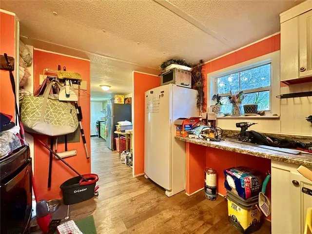 a kitchen with stainless steel appliances granite countertop a stove a refrigerator and a dining table with wooden floor