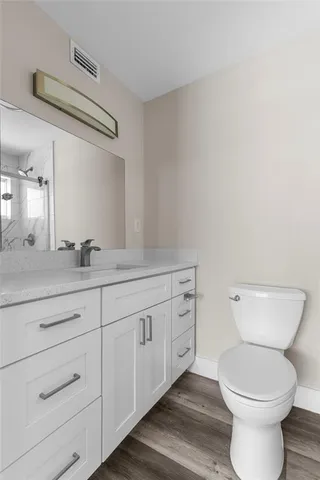 a bathroom with a toilet a sink and mirror