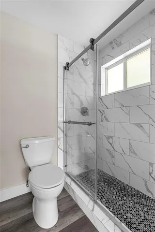 a bathroom with a toilet and a shower