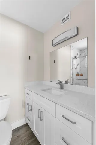 a bathroom with a sink a toilet and mirror