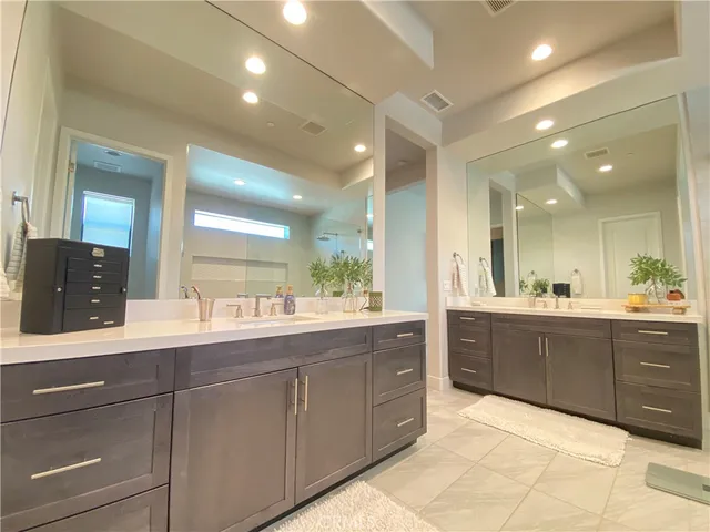 a spacious bedroom with a bed a chandelier and a window