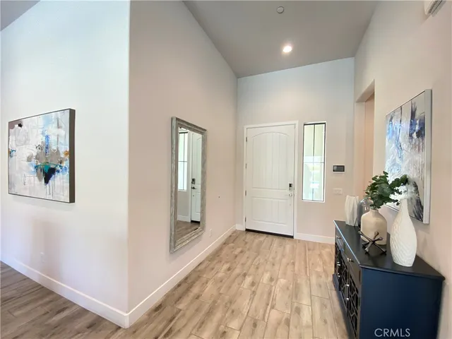 a view of a hallway with wooden floor and furniture