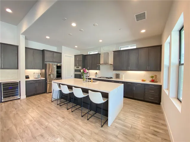a large kitchen with kitchen island a sink stainless steel appliances and cabinets