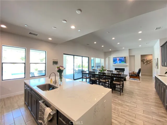 a kitchen with stainless steel appliances a table and chairs in it