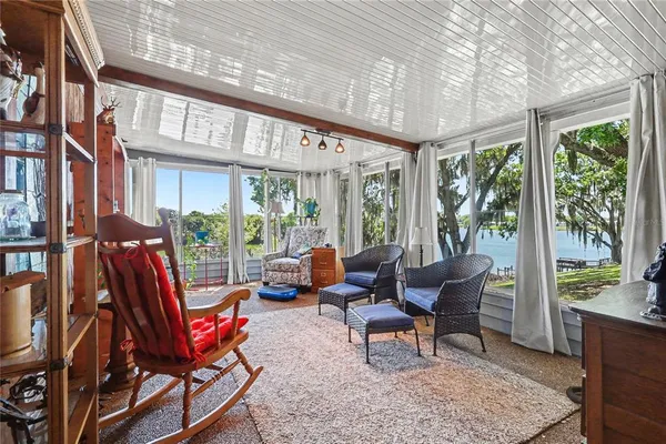 a living room with furniture a rug and a floor to ceiling window