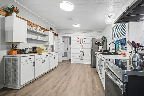 a kitchen with stainless steel appliances sink cabinets and wooden floor