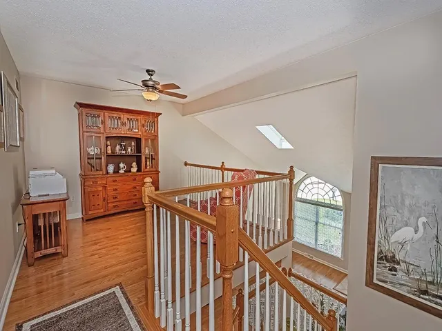 a view of a livingroom with furniture stairs wooden floor and windows