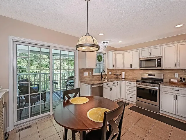 a kitchen with sink a stove and chairs