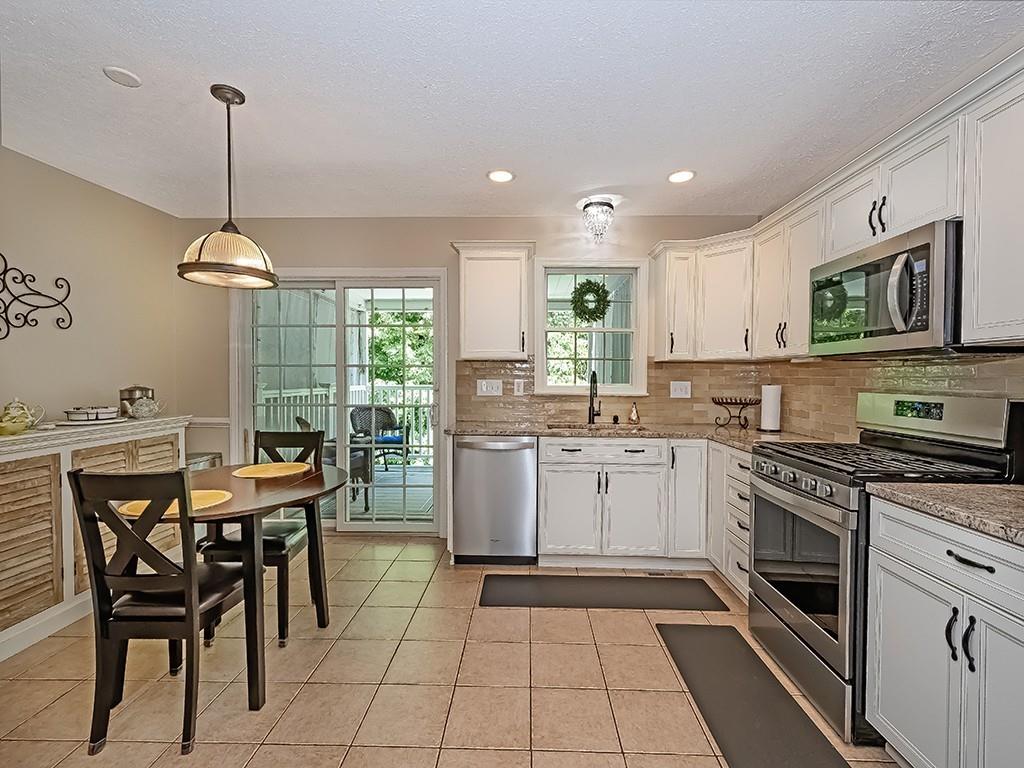 406 Country View Drive Lower Burrell, PA 15068 - Photo 14 of 31 a kitchen with a stove a sink a oven a dining table and chairs