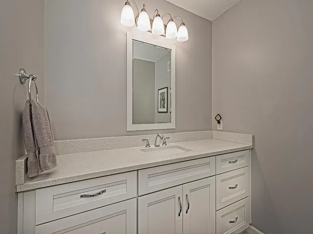 a bathroom with a sink vanity and mirror