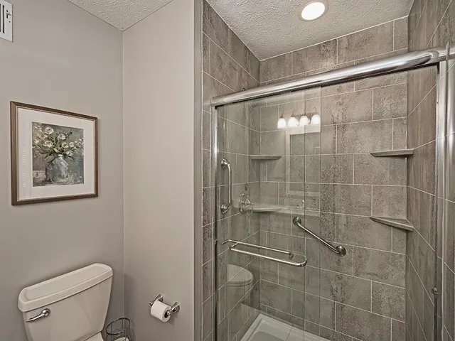 a bathroom with a toilet and a shower