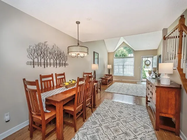 a view of a dining room and livingroom with furniture wooden floor a chandelier