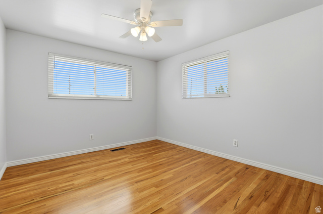 4245 3320 East Holladay, UT 84124 - Photo 26 of 51 Room featuring wood flooring, neutral wall paint, white trim, two windows with horizontal blinds, and a ceiling fan with integrated lighting