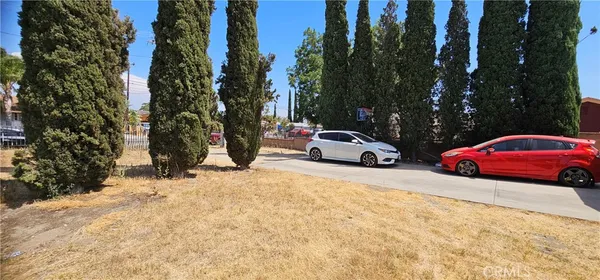 a car parked in front of a house with cars parked on road