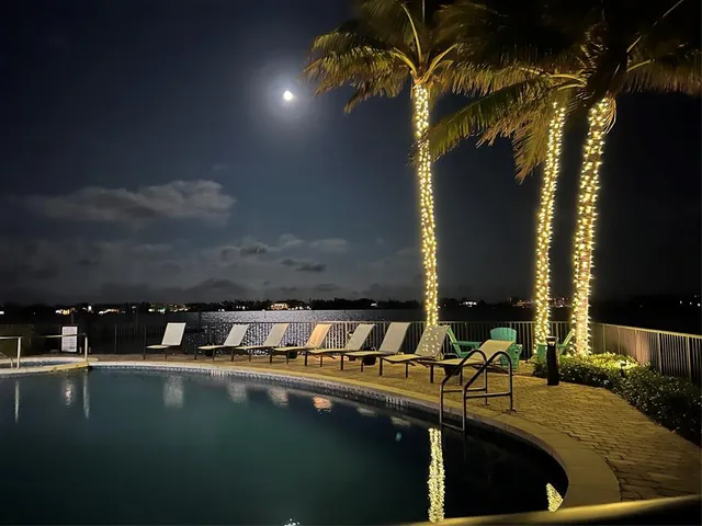 a kitchen with stainless steel appliances a sink a stove a microwave a refrigerator a stove with wooden floor