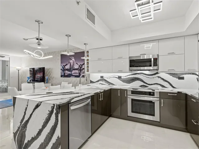 a kitchen with stainless steel appliances granite countertop a stove a sink and a refrigerator