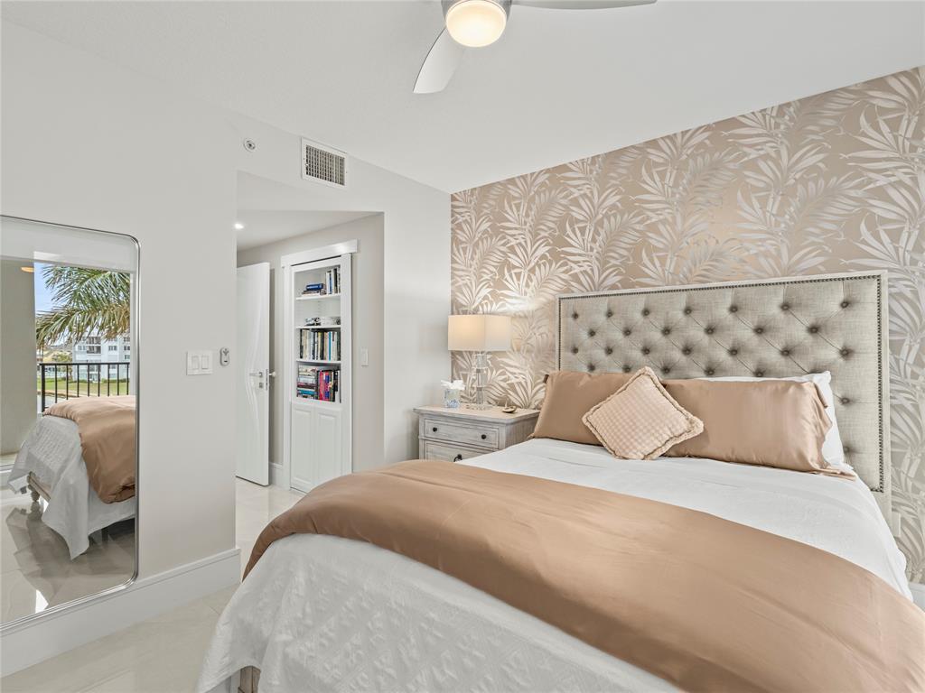 2700 North Federal Highway, Unit 407 Boynton Beach, FL 33435 - Photo 24 of 31 a bedroom with a large bed and a chandelier
