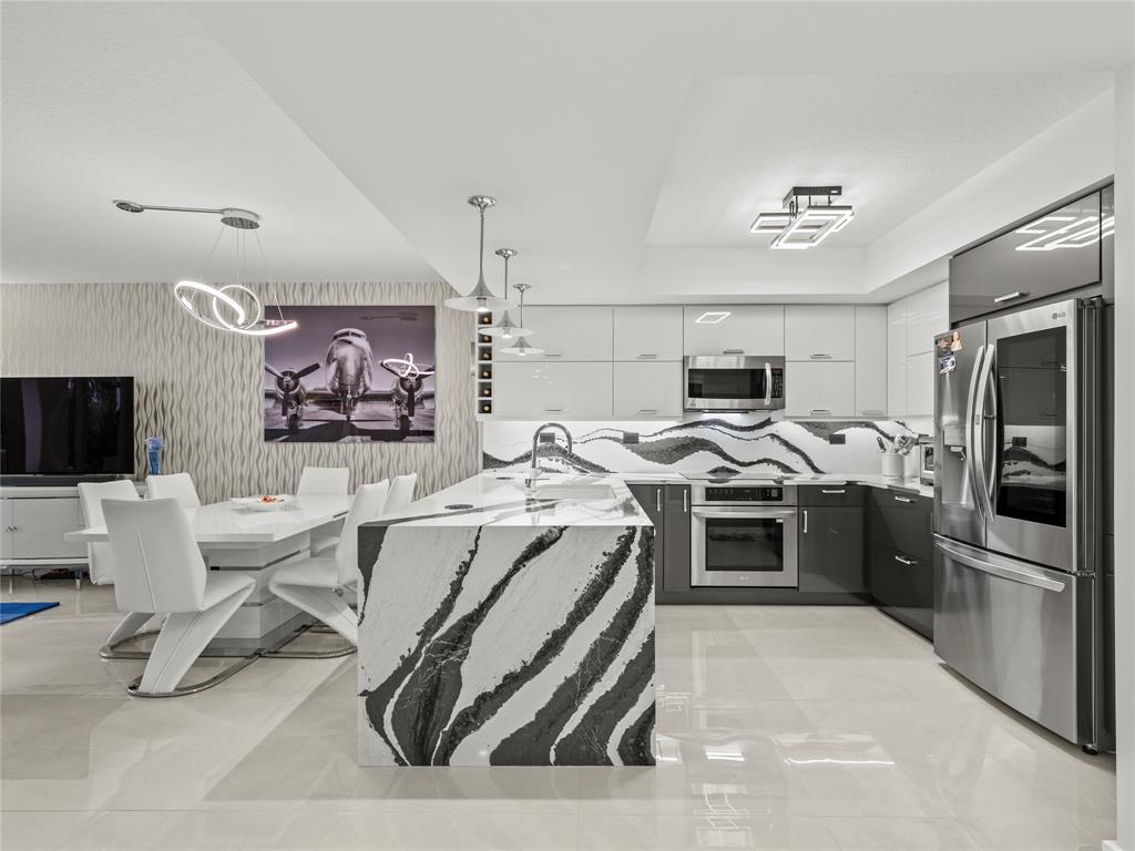 2700 North Federal Highway, Unit 407 Boynton Beach, FL 33435 - Photo 3 of 31 a kitchen that has a lot of cabinets a sink and a stove in it