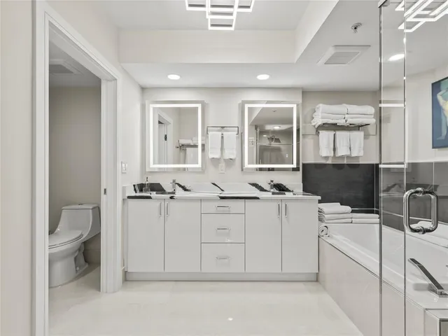a bathroom with a granite countertop sink mirror and toilet