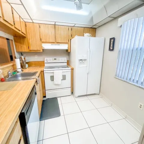 a kitchen with a stove a refrigerator and a sink