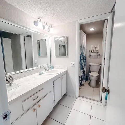 a spacious bathroom with a double vanity sink toilet and a mirror