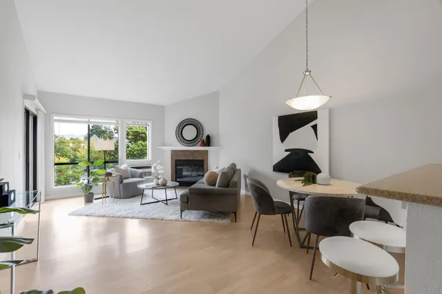 a living room with furniture a fireplace and a floor to ceiling window