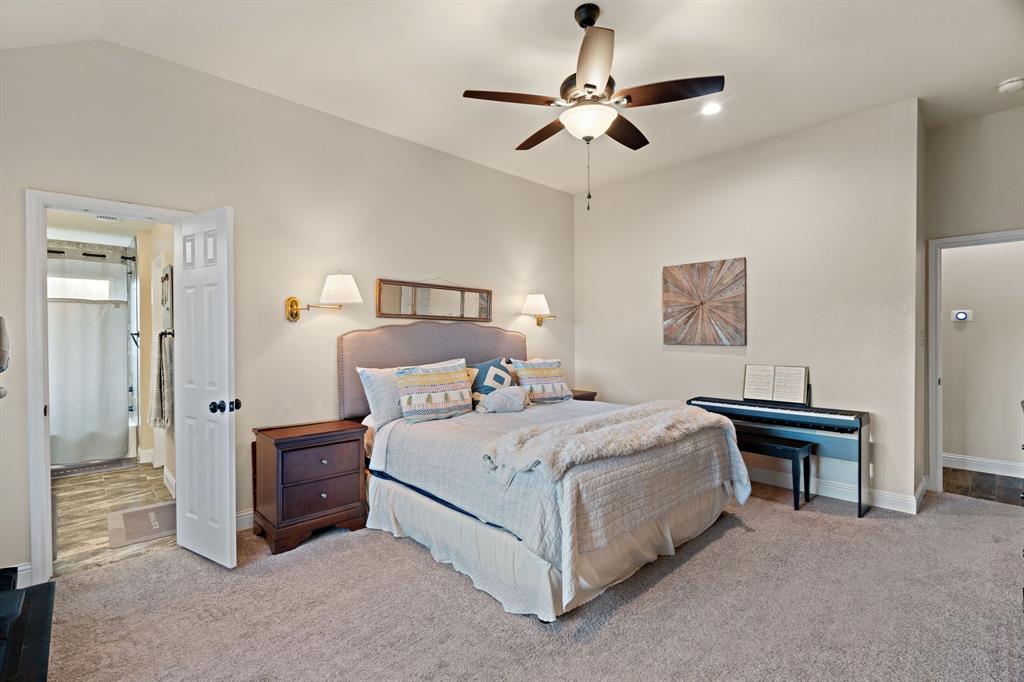 904 Sam Street Springtown, TX 76082 - Photo 15 of 30 a bedroom with a bed and a chandelier