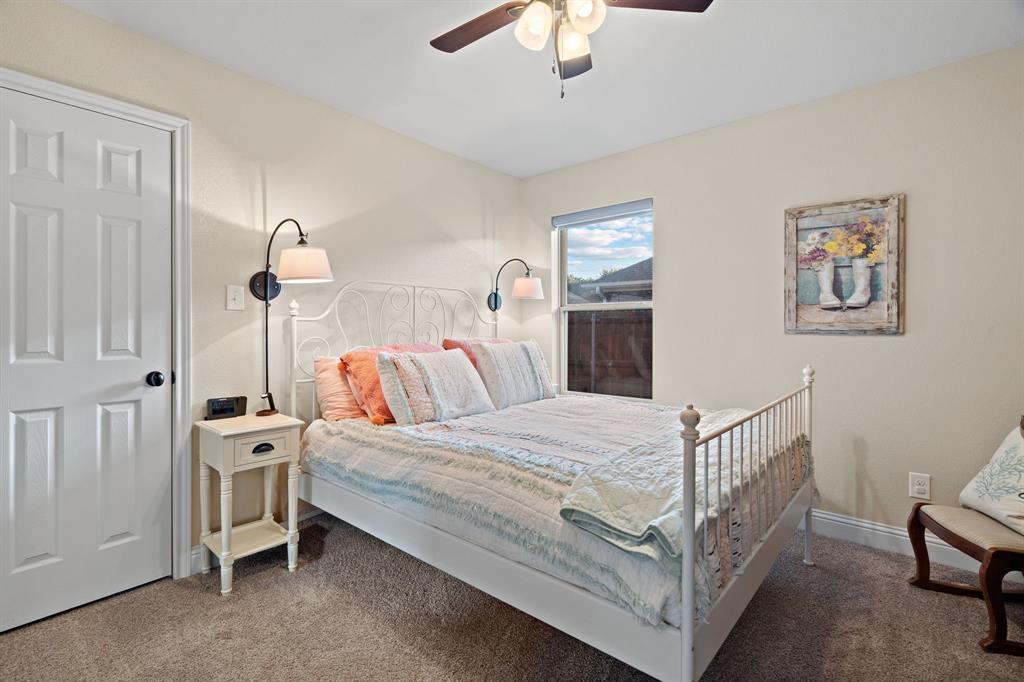 904 Sam Street Springtown, TX 76082 - Photo 19 of 30 a bedroom with a bed and a chandelier