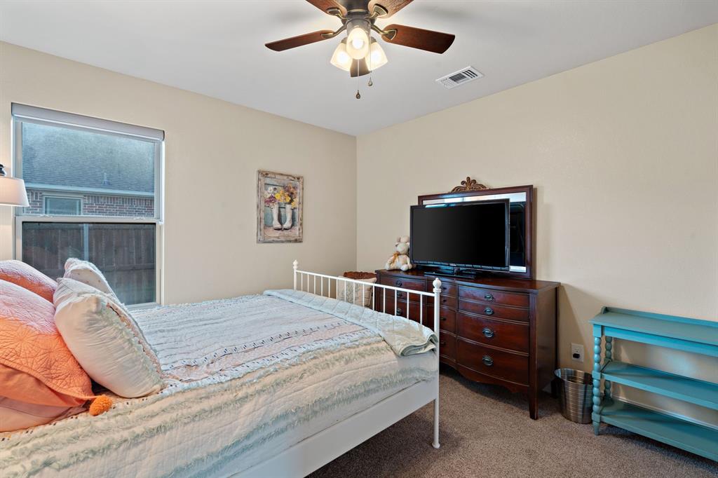 904 Sam Street Springtown, TX 76082 - Photo 20 of 30 a bedroom with a bed and a flat screen tv