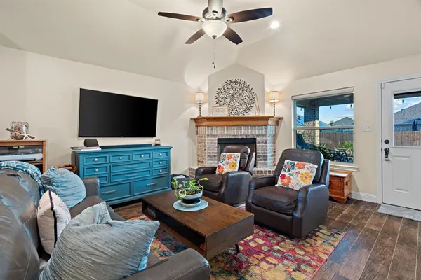 a living room with furniture a flat screen tv and a fireplace