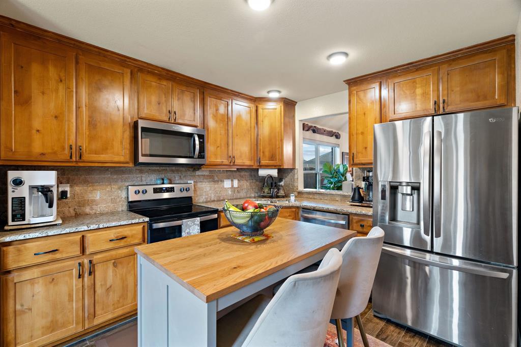 904 Sam Street Springtown, TX 76082 - Photo 10 of 30 a kitchen with stainless steel appliances a stove refrigerator sink and cabinets