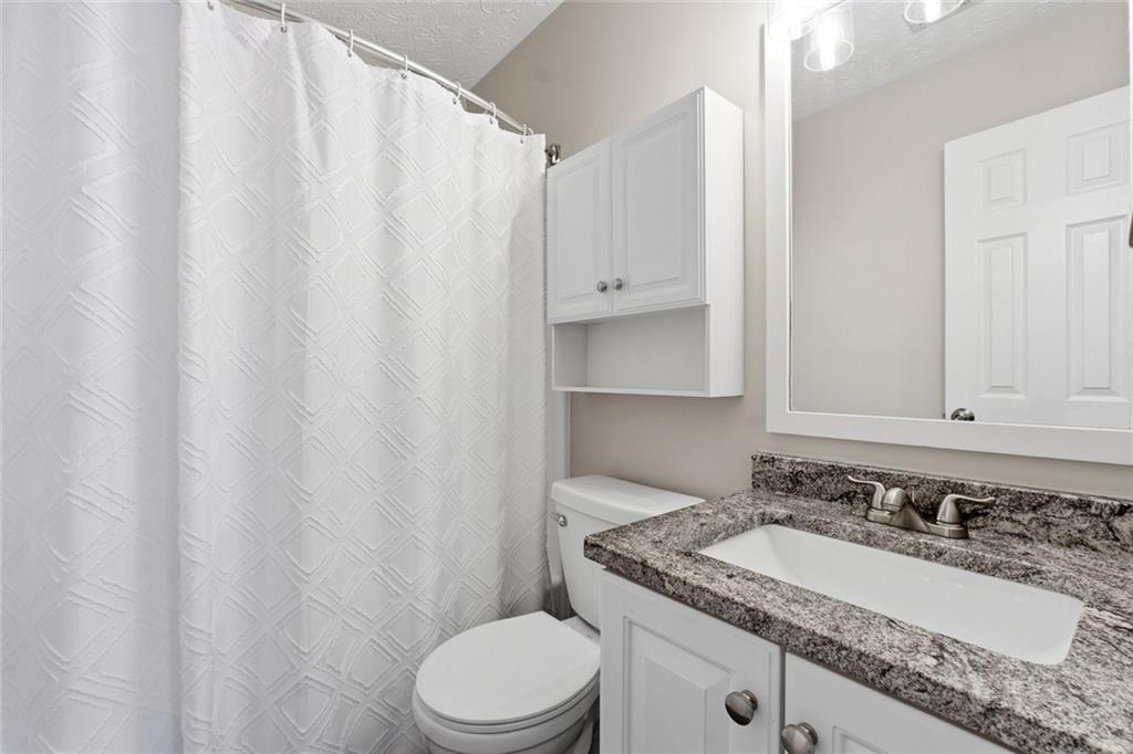 1001 Daventry Crossing Woodstock, GA 30188 - Photo 15 of 22 a bathroom with a granite countertop sink vanity mirror and toilet