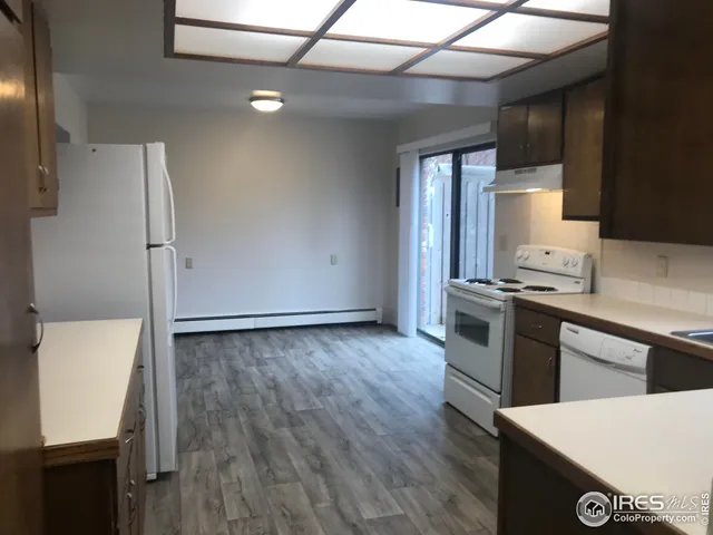 a kitchen with granite countertop a refrigerator and a stove top oven