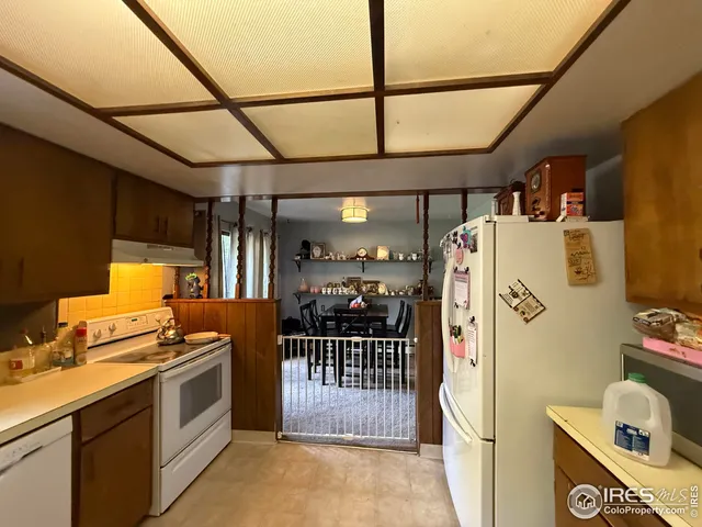 a kitchen with a refrigerator and white cabinets