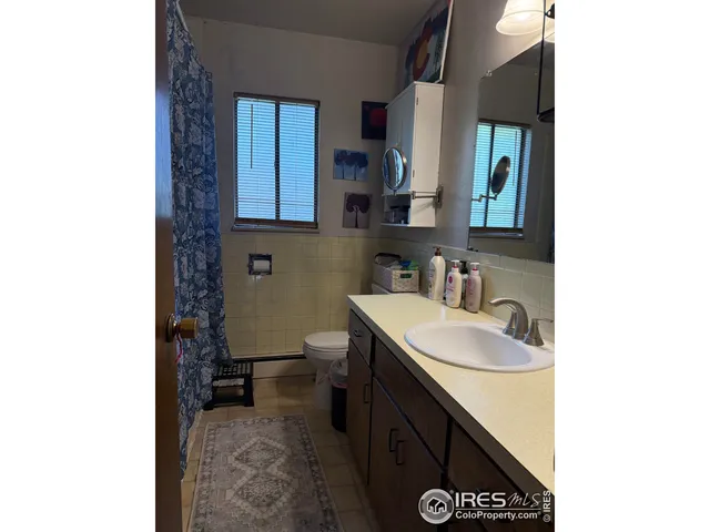 a bed sitting in a bedroom next to a window with a flat screen tv and a fireplace