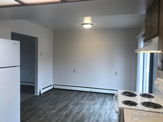 a view of kitchen with stainless steel appliances wooden floor and a refrigerator