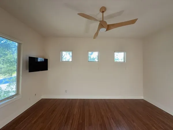 a view of empty room with wooden floor