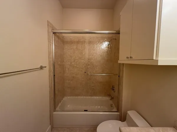 a bathroom with a granite countertop sink a toilet and a mirror