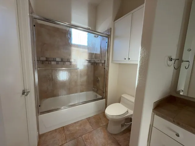 a bathroom with a granite countertop toilet and a sink