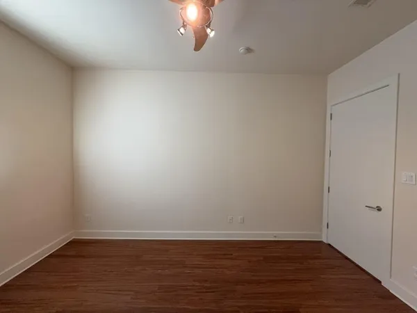 a view of a room with wooden floor and a ceiling fan