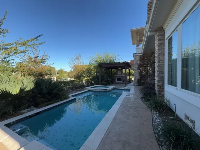 an empty room with wooden floor fireplace and a window