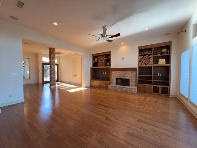 a kitchen with stainless steel appliances granite countertop a refrigerator and a wooden floors
